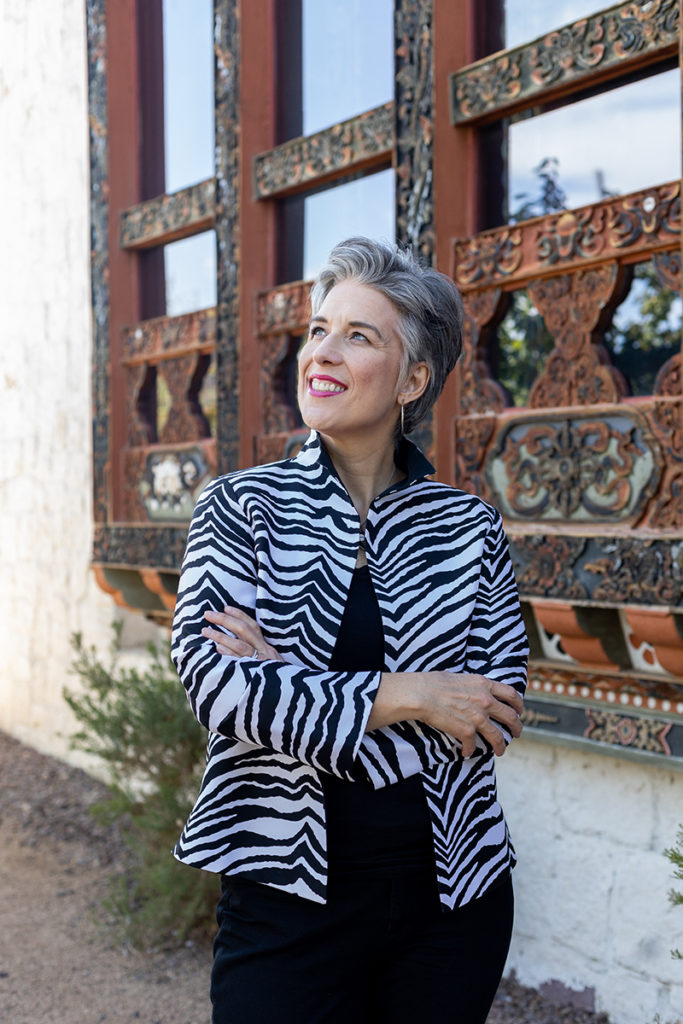 Woman looking off in the distance, wearing a black-and-white striped jacket